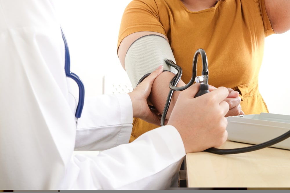 Asian,female,doctors,measure,pressure,on,very,obese,patients,for