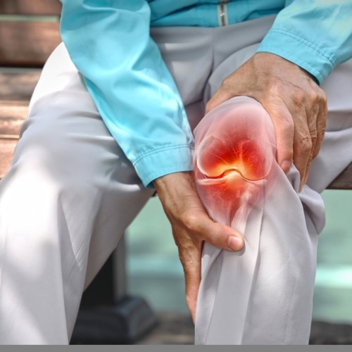 Close,up,of,elderly,woman,holding,knee,with,pain,due