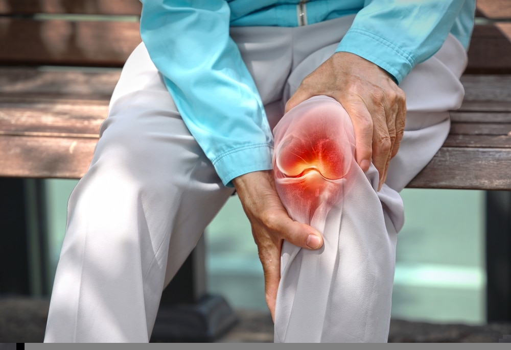 Close,up,of,elderly,woman,holding,knee,with,pain,due