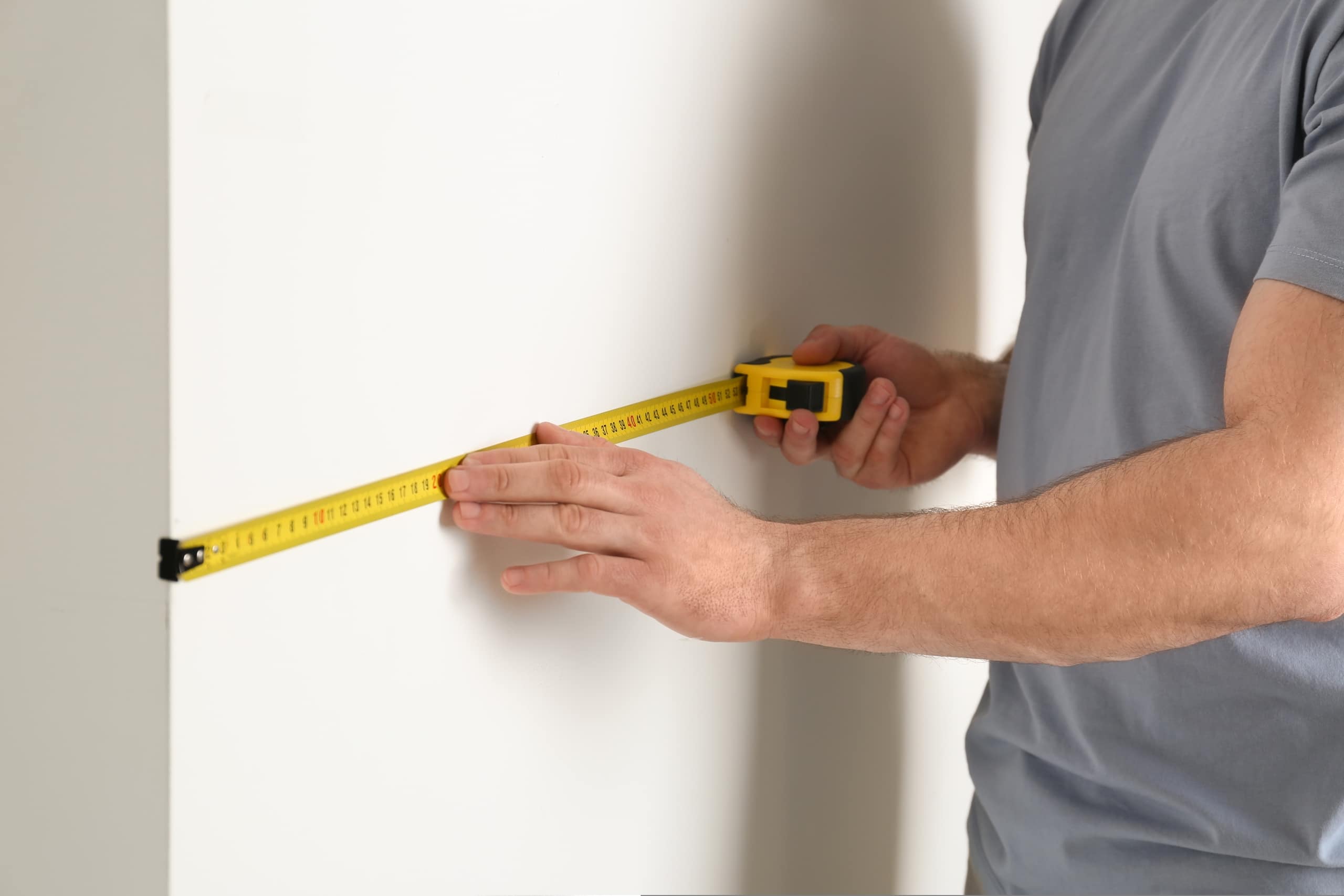 Man,measuring,white,wall,indoors,,closeup.,construction,tool