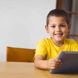 Smiling Child Sat At Table