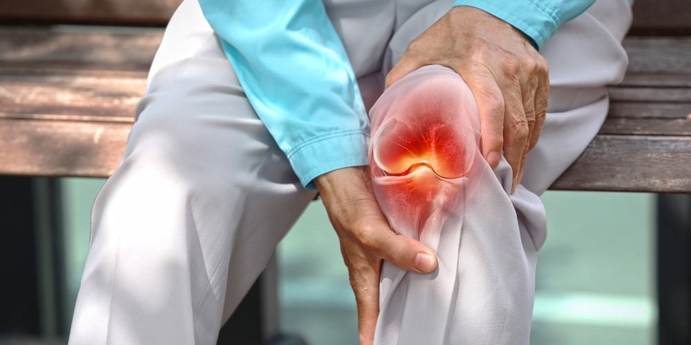 Close,up,of,elderly,woman,holding,knee,with,pain,due